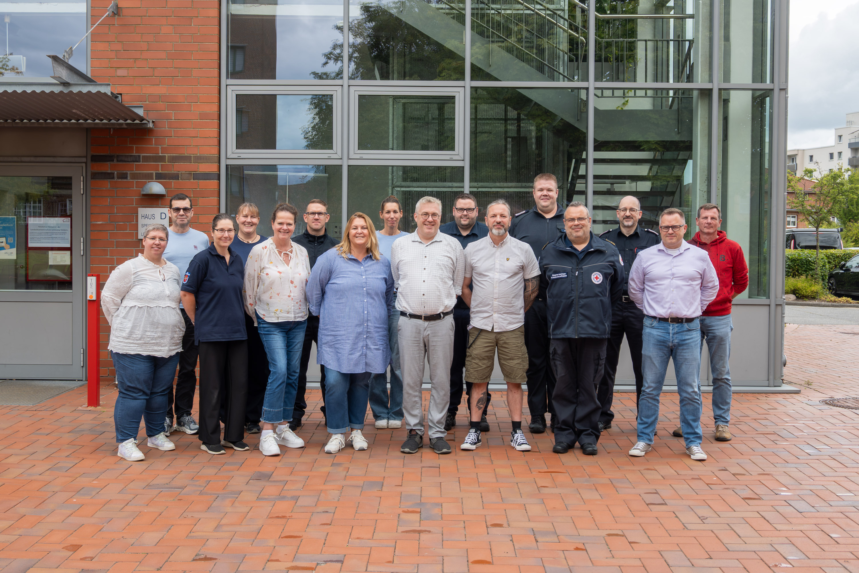 Teilnehmende des Lehrgangs Grundlagenschulung Operativ-taktische Stabsarbeit haben sich zum Gruppenfoto auf dem Innenhof der LFS.SH aufgestellt